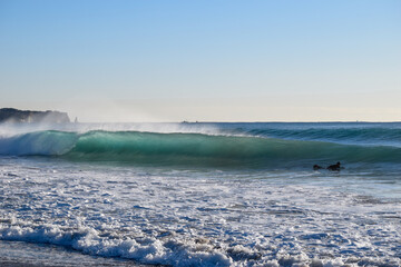 Surfer on Blue Ocean Wave riding on surfing board in Asia.  Japan is famous for its great waves near to Tokyo City