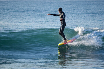 Surfer on Blue Ocean Wave riding on surfing board in Asia.  Japan is famous for its great waves near to Tokyo City