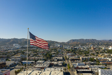 Drone, aerial shot of American Flag with Los Angeles and Hollywood as a background