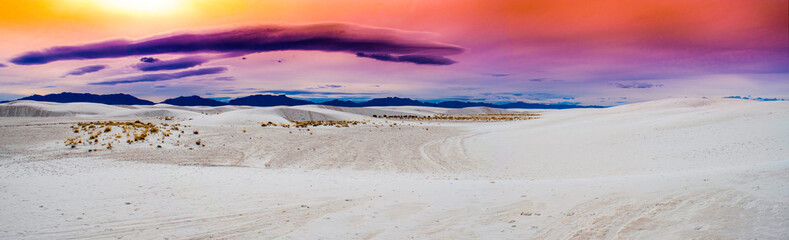 Rolling gypsum sand dunes of White Sands National Park, New Mexico USA.  With vivid colors on horizon with dark mountains.  - Powered by Adobe