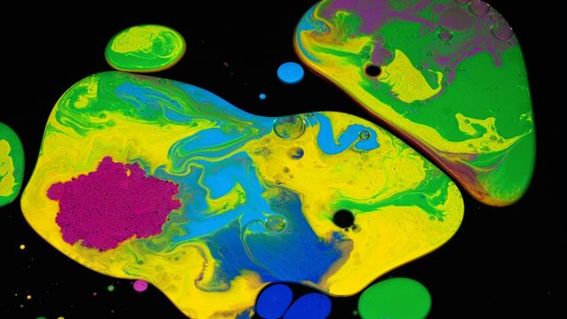 Fluid art background with colorful tints, liquid surface. Stock footage. Amazing effect of acrylic paints on black canvas, mixing different bright colors.