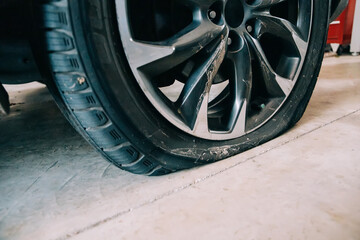 a flat tire on an automobile in a car garage with copy space