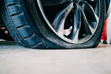 a flat tire on an automobile in a car garage with copy space