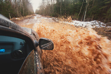 Obraz premium Suv offroad 4wd car rides through muddy puddle, off-road track road, with a big splash, during a jeeping competition