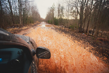 Suv offroad 4wd car rides through muddy puddle, off-road track road, with a big splash, during a jeeping competition