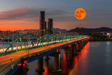 Twilight at Dongjak Bridge at Han river with full moon and seoul tower in Seoul City , South Korea