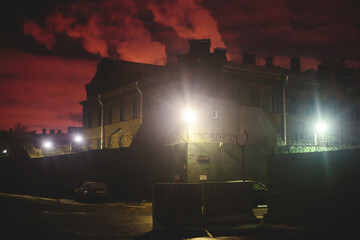 A night view of protected creepy penitentiary prison building facility, asylum exterior with barded...