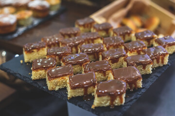 Decorated breakfast catering setting at the hotel, with variety of dishes: cereal, corn flakes, vegetables, toast, pancakes, pastry, cupcakes and other food