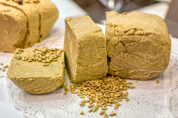 A large piece of yellow halva is cut into several parts.