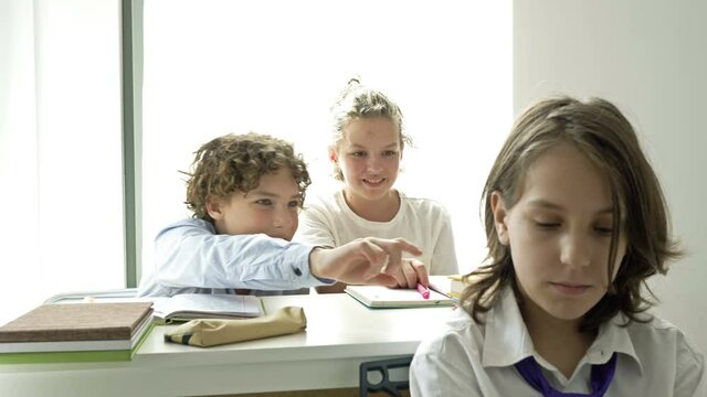 Two teens scoff at their defenseless classmate. Child cruelty. School bullying.