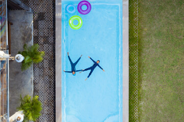 Aerial view or top view of children are swimming in the swimming pool