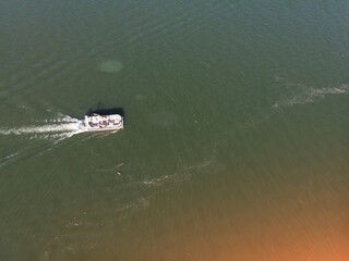 The boat is floating at speed on the water with a spot, top view with space, background and texture