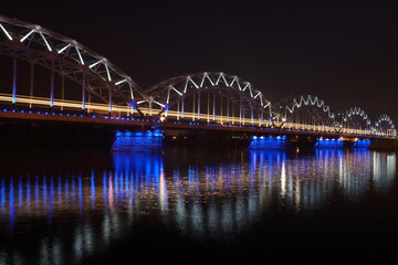 Glittering night scene of the Railway Bridge Daugava River in Riga Latvia. Photo for art decoration and blog story.