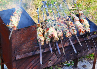 Cooking juicy meat in the summer on a picnic in the coals on the grill and skewer