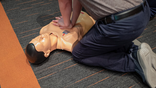 Low Section Of Paramedic Performing Cpr On Dummy