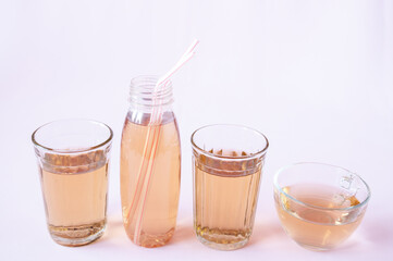 Glassware with Apple juice on a pink background