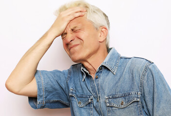 lifestyle, health and people concept: Senior man has headache, on white background