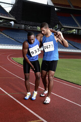 Male athlete helping another injured athlete