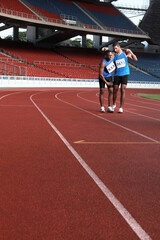 Fototapeta premium Male athlete helping another injured athlete