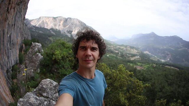 A man takes a selfie against the backdrop of a beautiful mountain valley and rocks, A man travels through the picturesque places of the world, Turkey Rocks, Rock Climbing in Turkey.