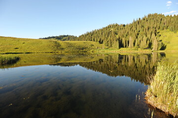 Flood of the river in a wide valley against the background of hills with different vegetation. Sunset time of day.