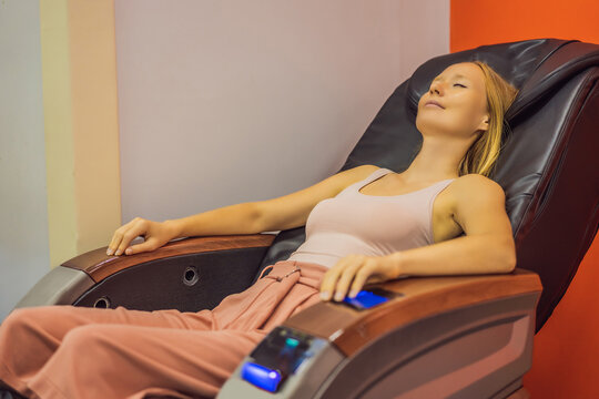 Beautiful Young Woman Relaxing On The Massage Chair In Airport Or In The Mall