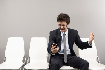 Businessman looking disappointed after reading text messages on mobile phone