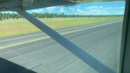 Wheel of a small plane as it taxi's down a runway of a small private airport on a sunny clear day.