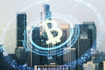 Double exposure of creative Bitcoin symbol hologram on Los Angeles city skyscrapers background. Cryptocurrency concept