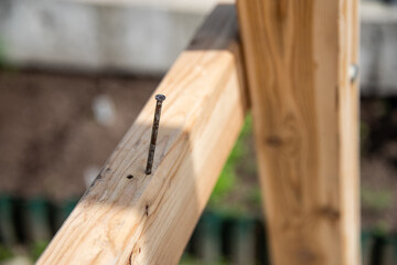 rusty nail sticking out of a wooden board