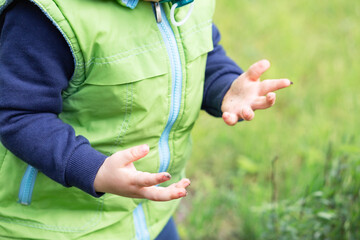 The child's hands are dirty after playing with the ground