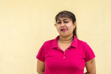 Indian female model looking straight naughty face in yellow background with copy space for text
