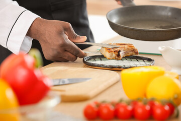 Male African-American chef cooking in kitchen, closeup