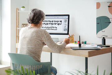 Senior male calligraphist working in office