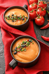 Cups of tasty lentils soup on dark background