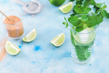 Glass of fresh mojito on color background