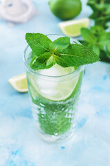 Glass of fresh mojito on color background