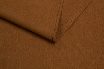 Fabric jeans fold top view. Brown textile	
