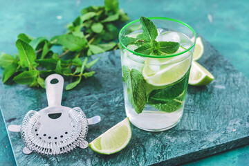 Glass of fresh mojito on color background