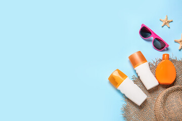 Beach accessories with sunscreen cream on color background