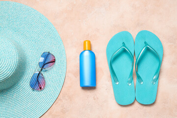 Beach accessories with sunscreen cream on color background