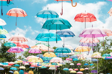 Fototapeta na wymiar Concept colorful umbrella floating in the bright blue sky background.