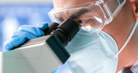 man scientist use microscope