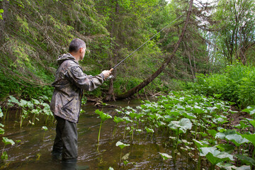 Naklejka premium fisherman with a spinning performs retrieval