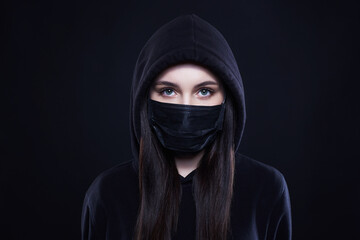 Young Woman in Mask and Hood. Girl in black Mask and Hoodie.
