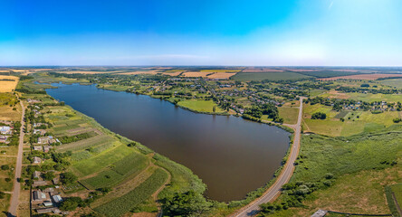 Blue pond on the Zelenchuk II river near the village of Staroarmyanskoye (Krasnodar Territory, South of Russia) surrounded by wheat fields - aerial drone small panorama on a sunny day