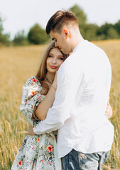 Beautiful loving couple standing in the field,  summer mood