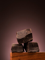 Large pieces dark chocolate on a dark background