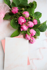 mock wedding card. a bouquet of pink roses, a wedding ring and an envelope with place for text. congratulation. invitation