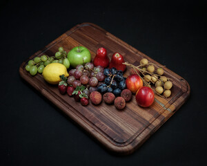 photo of wooden cutting board products and wooden trays, by adding properties to a variety of fresh fruit. Looks very attractive and elegant.
